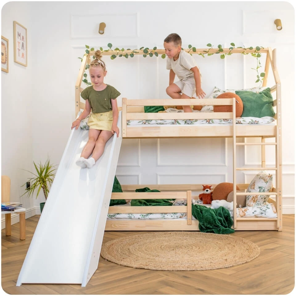 Pine PLAY house-shaped bunk bed with ladder and slide. Two children are playing on the bed.